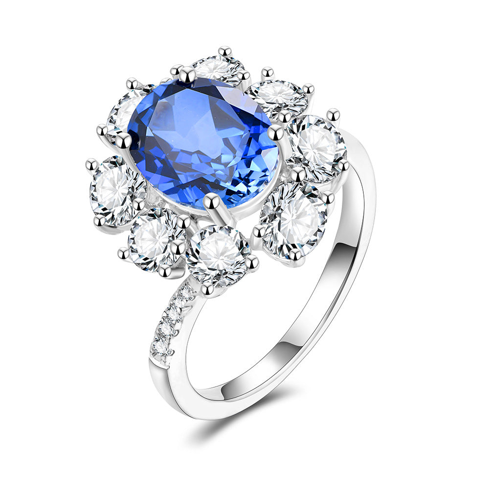 Oval lab-grown blue sapphire cluster ring on white background