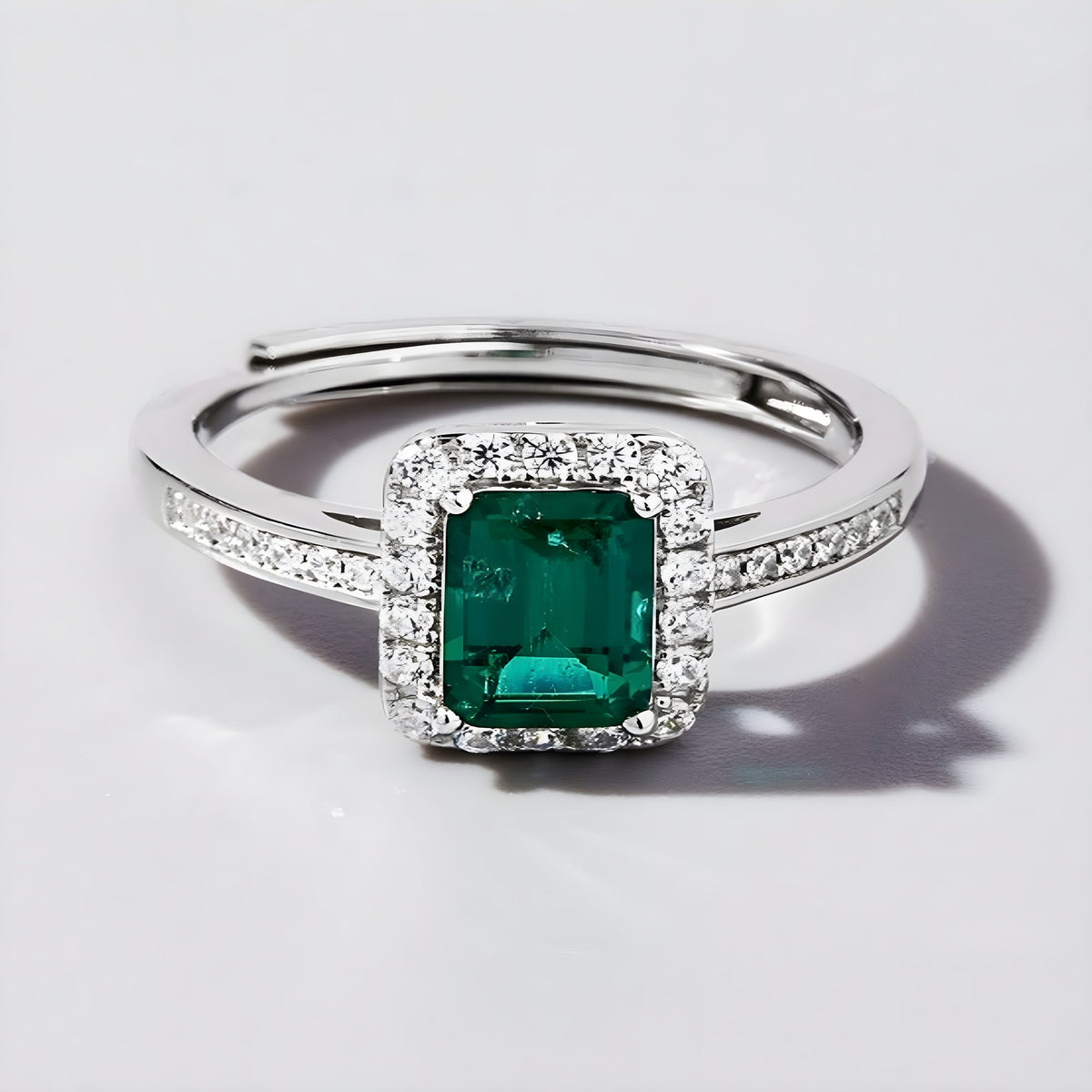 Front view of green lab-grown emerald halo ring in polished sterling silver
