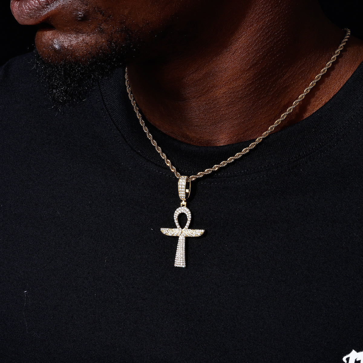 Gold-tone Ankh cross moissanite pendant shown for scale