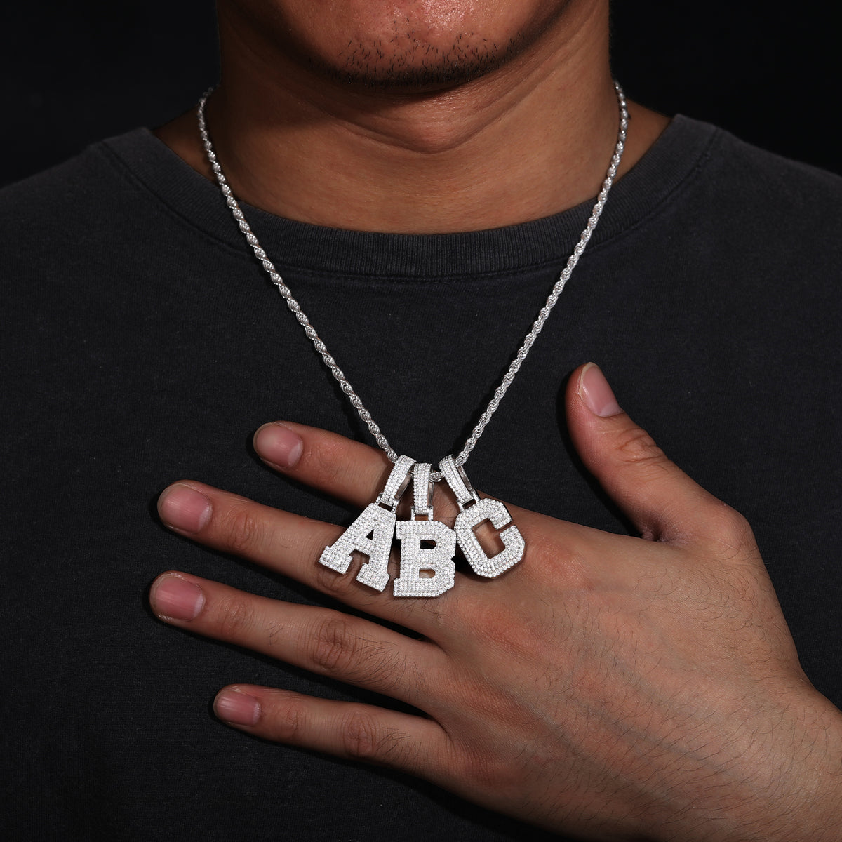 Block letter moissanite initial pendants worn on a chain