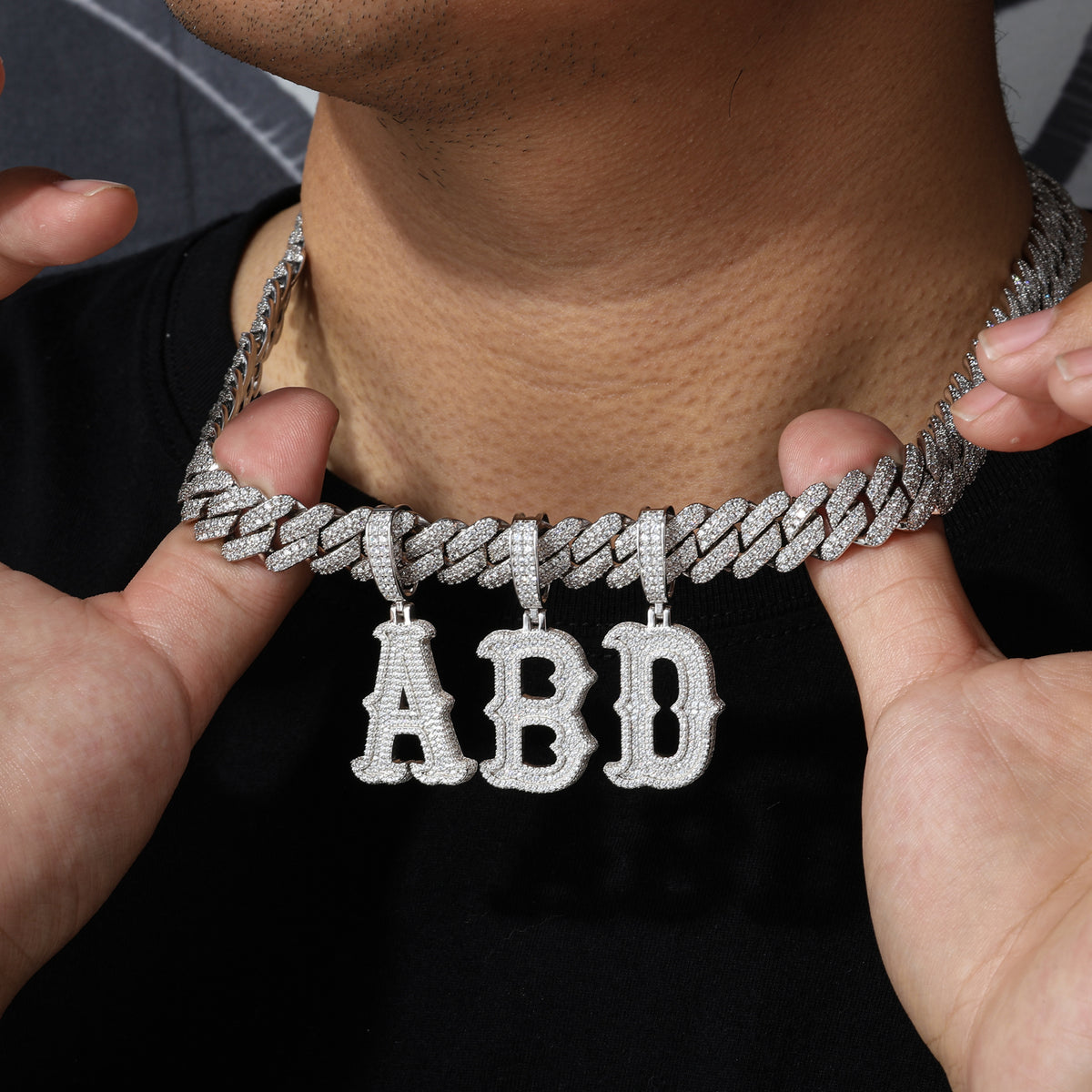 Bubble letter moissanite initial pendants worn with Cuban chain