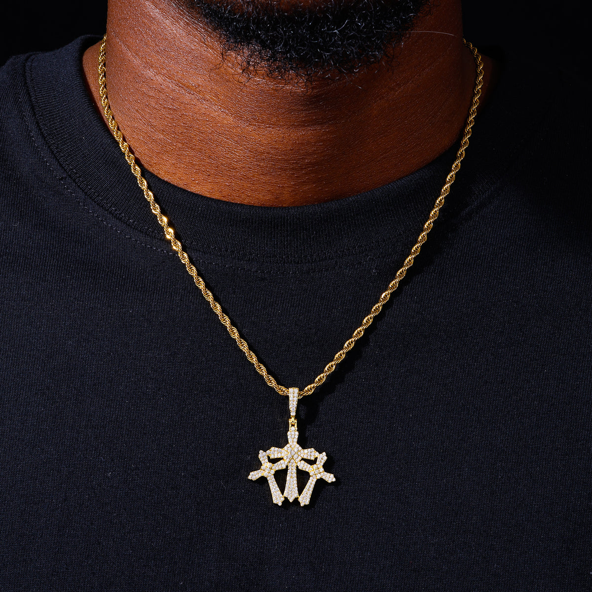Gold-tone compact triple cross moissanite pendant shown for scale