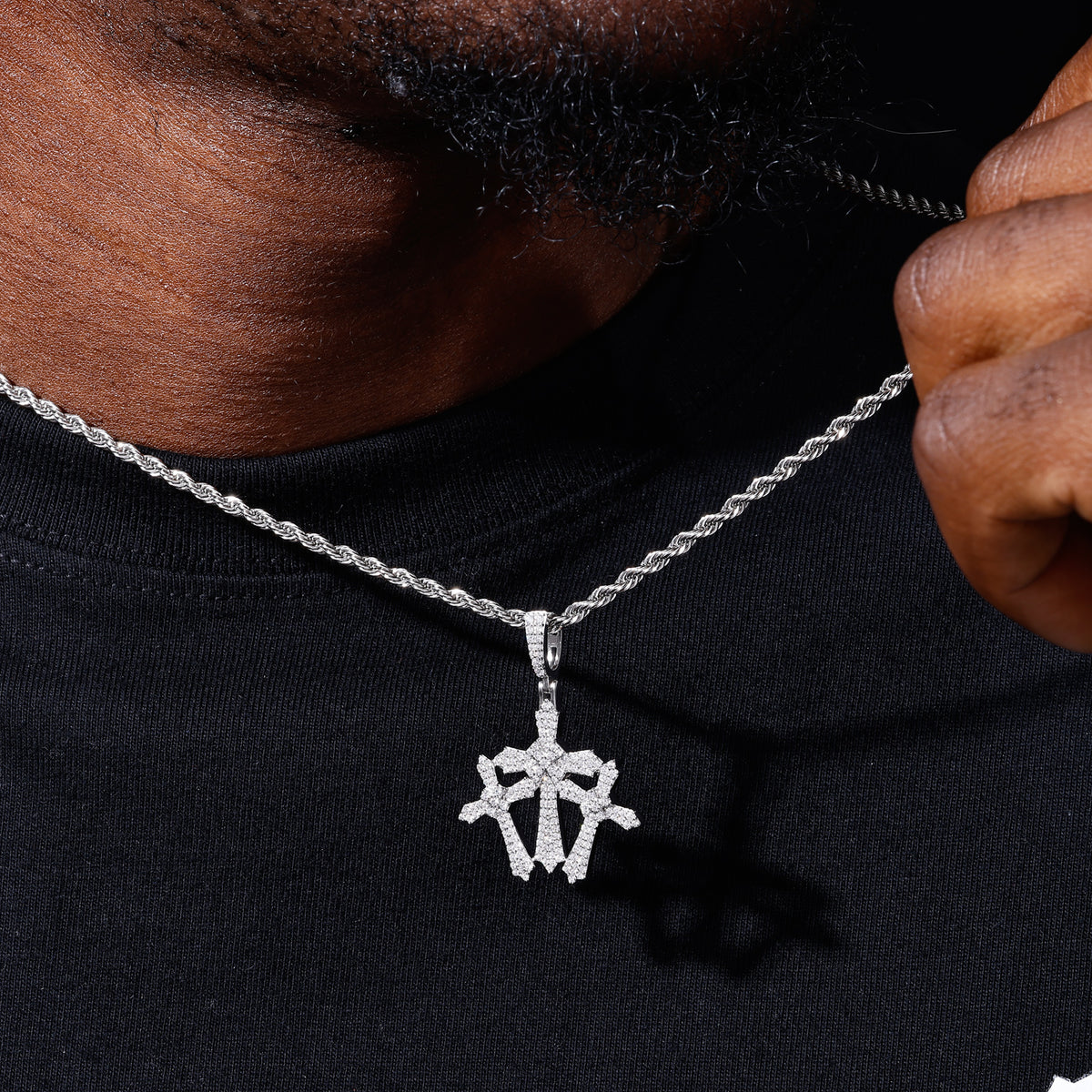 Silver-tone compact triple cross moissanite pendant shown for scale