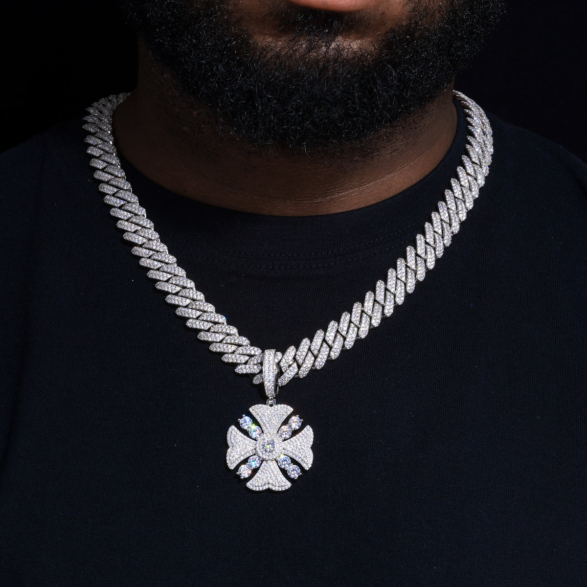 Iced-out floral halo cross moissanite pendant worn with a Cuban link chain