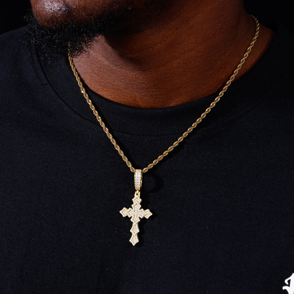 Gold-tone layered lily cross moissanite pendant shown for scale