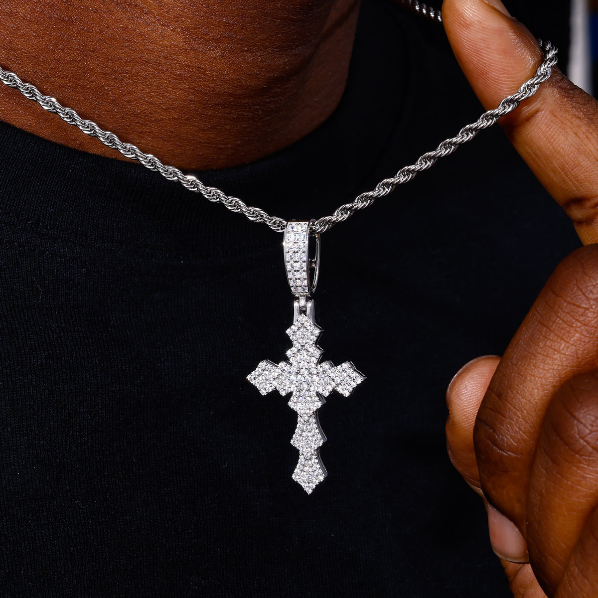 Silver-tone layered lily cross moissanite pendant shown for scale