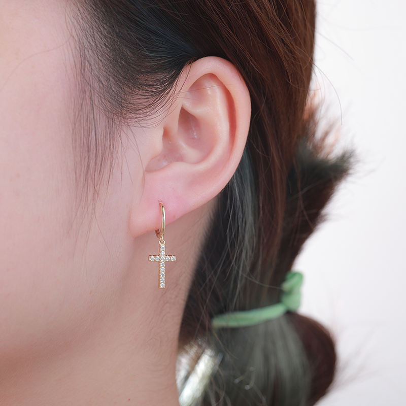 Cross hoop earring worn