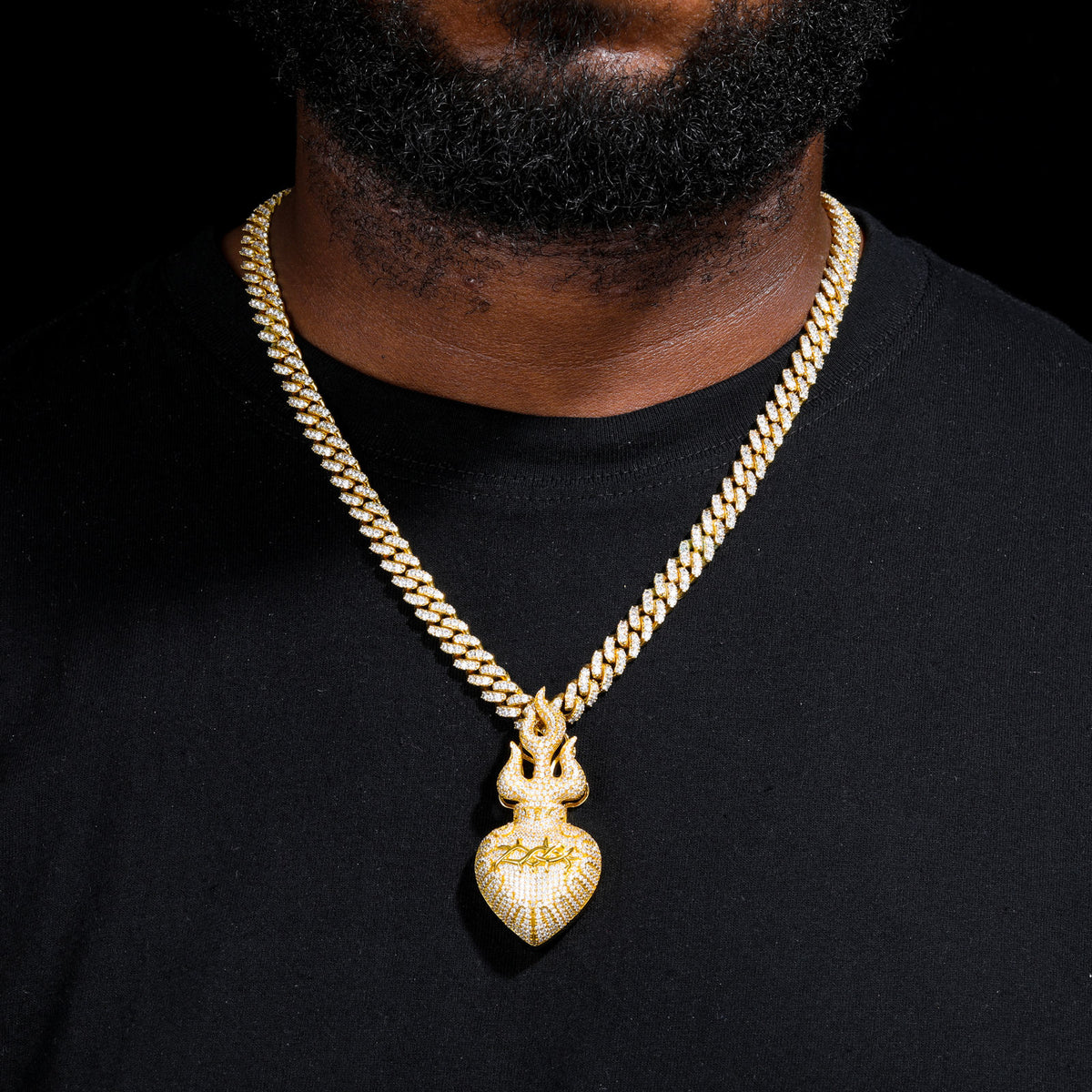Gold-tone flame heart pendant worn