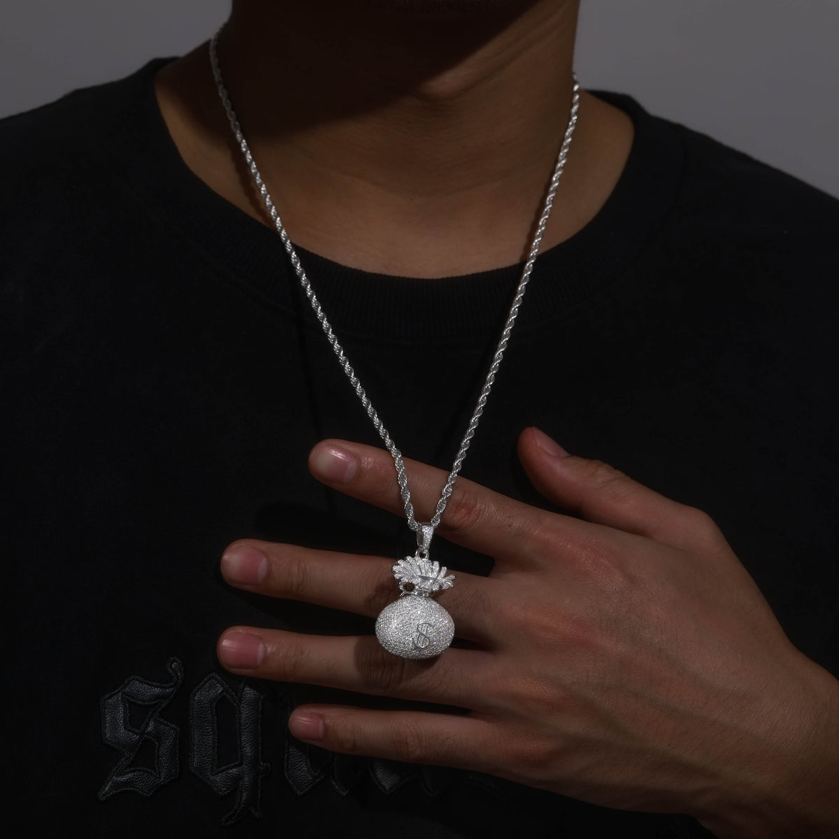 Iced-out money bag pendant styled with a silver-tone chain