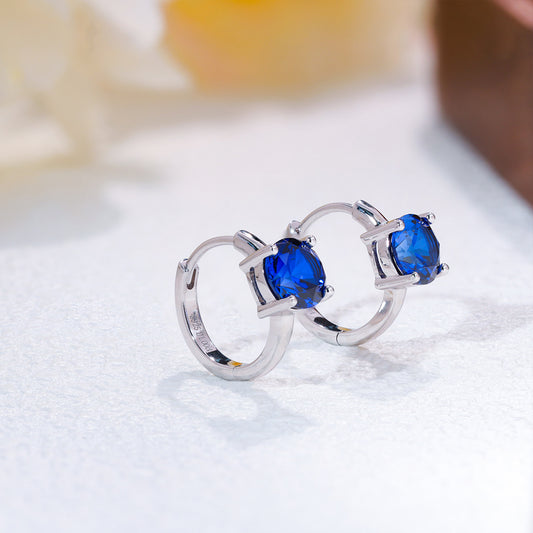 Round lab-grown blue sapphire huggie earrings in 925 sterling silver, pair view