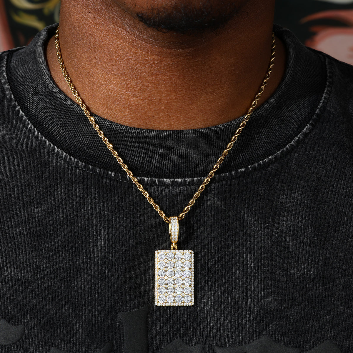 Gold-tone square moissanite dog tag pendant worn on rope chain