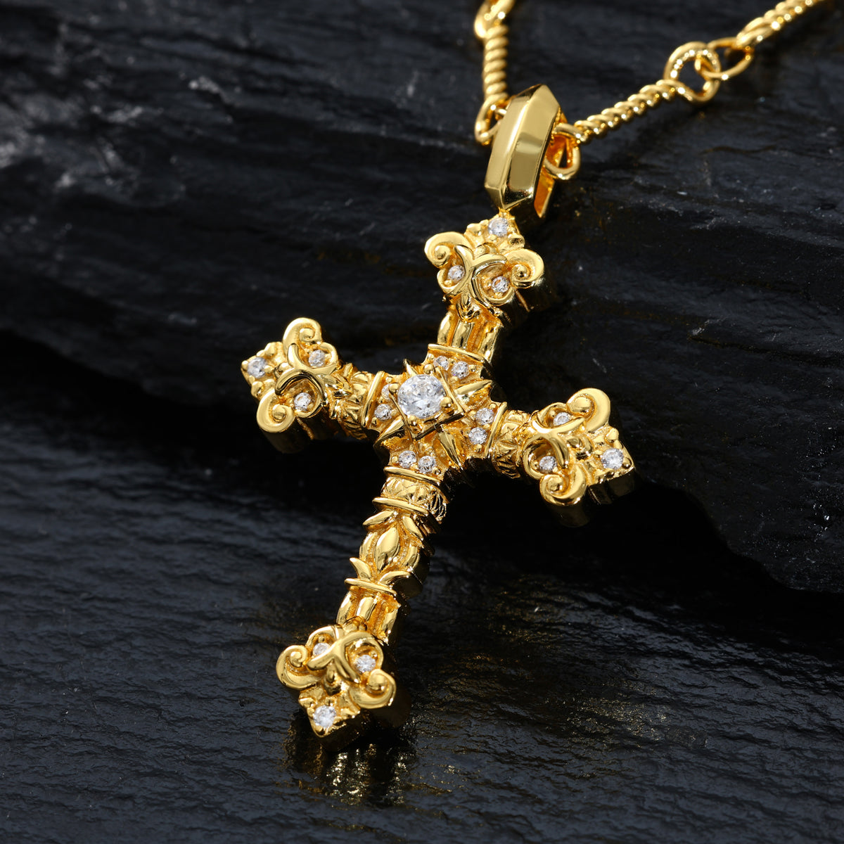 Gold-tone ornate iris cross pendant detail